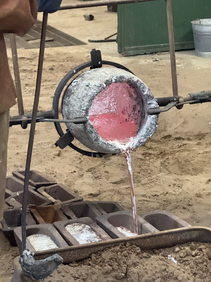 A craftsperson shaping a metal garden object